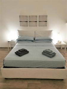 a large white bed with two towels on it at Casa Giulia a 500 mt dal mare in Montesilvano