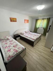 a bedroom with two beds and a window at La Buna Văliug in Văliug