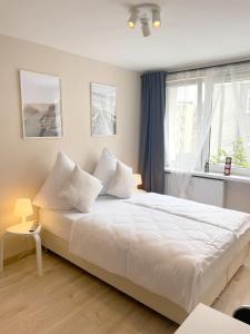 a bedroom with a bed with white sheets and a window at 09 Gdynia Centrum - Apartament Mieszkanie dla 2 os in Gdynia