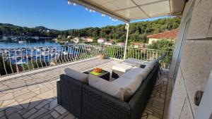 a couch on a balcony with a view of a marina at Truly Mediterranean Apartment "Spark" in Korčula