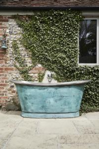 a large blue tub sitting in front of a building at The Cottages at Launceston Farm in Blandford Forum