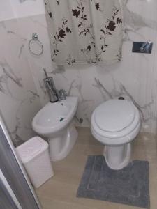 ein Badezimmer mit einem weißen WC und einem Waschbecken in der Unterkunft Casa The life in Trapani