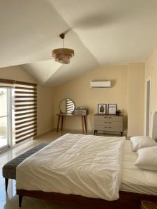 ベレキにあるBelek Golf Village Apartmentsのベッドルーム(大きな白いベッド1台、テーブル付)