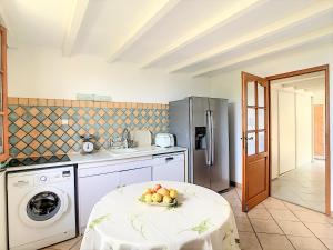 uma cozinha com uma mesa com uma taça de fruta em Maison avec piscine entre mer et montagne em Muro