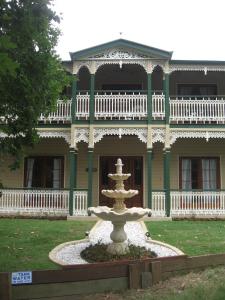 a fountain in front of a large house at Grove Manor in Brisbane