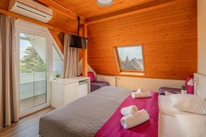 a bedroom with a bed with two towels on it at Admiral Family Resort in Keszthely +26 photos