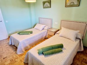 a room with two beds with green pillows on them at Las Mejores VISTAS de SALAMANCA!!! in Salamanca