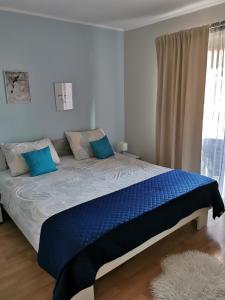 a bedroom with a large bed with blue sheets at Apartments Pecotić in Brna