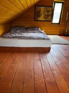 uma cama num quarto com piso em madeira em Klimatyczny drewniany domek w górach em Lachowice