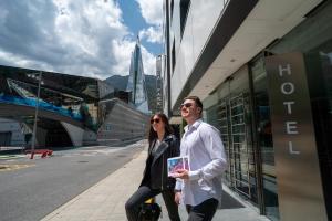 a man and a woman standing in front of a building at Yomo Mola Park in Andorra la Vella