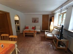 uma sala de estar com um sofá e uma mesa em Ferienwohnung Wasserfall em Schliersee