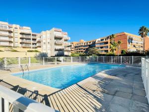 a swimming pool with buildings in the background at Très bel appartement face au port Santa -Piscine in Saint-Raphaël