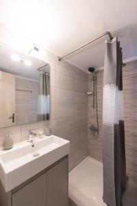 a bathroom with a sink and a shower at Magdalenia's cozy apartments in Nafplio