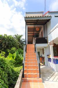 an orange staircase leading up to a house at Bangtao Guest House in Bang Tao Beach
