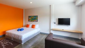 1 dormitorio con 1 cama y TV de pantalla plana en Bangtao Guest House, en Bang Tao Beach