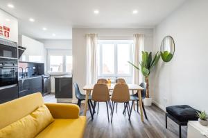 ein Wohnzimmer mit einem gelben Sofa, einem Tisch und Stühlen in der Unterkunft Akicity Arroios Red in Lissabon