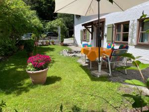 un patio con mesa, sillas y sombrilla en Ferienwohnung Wasserfall, en Schliersee