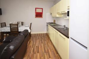 Apartment 701 - Letterfrack في ليترفراك: غرفة معيشة مع أريكة ومطبخ مع طاولة