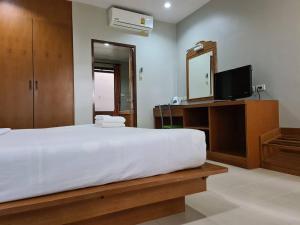 a bedroom with a bed and a mirror and a tv at ก้านกล้วยแมนชั่น Gankluy Mansion in Phuket Town