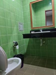 a green bathroom with a sink and a toilet at ก้านกล้วยแมนชั่น Gankluy Mansion in Phuket Town