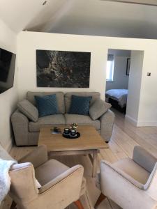 sala de estar con sofá y mesa en The Loft, en Crowborough