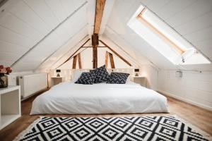 a bedroom with a white bed and a skylight at AVA HOUSE in Podkoren