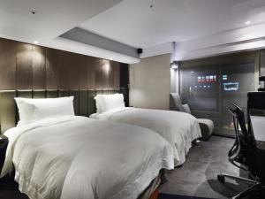 Rúm í herbergi á The Tango Hotel Taipei FuHsing