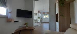 a living room with a television on a white wall at Apartment Sunrise, Polje - otok Krk in Polje