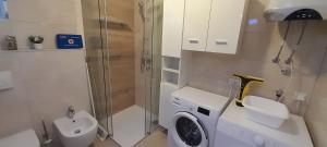 a bathroom with a toilet and a washing machine at Apartment Sunrise, Polje - otok Krk in Polje