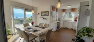 a dining room with a table and chairs and a kitchen at Apartment Sunrise, Polje - otok Krk in Polje