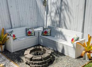 a bench with two pillows and a fire pit at Private Outdoor Spa, Fire Pit, Cinema Room - THE COTTAGE COOLUM BEACH in Coolum Beach