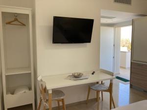 a room with a table and a tv on the wall at Casa Antonia in Mesagne
