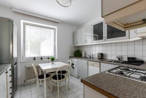 eine Küche mit weißen Geräten sowie einem Tisch und Stühlen in der Unterkunft Retro Apartment in the city center. in Wien