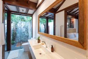 ein Bad mit einem Waschbecken und einem Spiegel in der Unterkunft Colibri Beach Villas in Ilha de Boipeba
