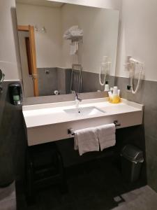 a bathroom with a white sink and a mirror at Hotel Marítimo Ris con garaje in Noja
