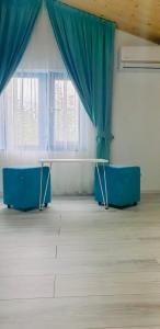 um quarto com uma mesa e cortinas azuis em Delta Blue em Maliuc