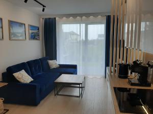salon z niebieską kanapą i stołem w obiekcie Apartamenty Marzeń w Grzybowie