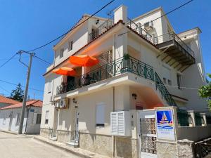 un edificio bianco con ombrelloni arancioni sul balcone di Gallery Apartments a Lixouri