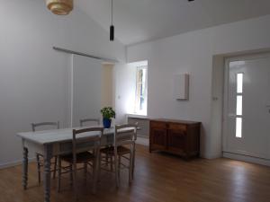 una sala da pranzo con tavolo e sedie di Guest house aux portes du Bassin d'Arcachon a Mios