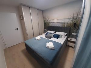1 dormitorio con 1 cama con toallas en Apartamenty Marzeń, en Grzybowo