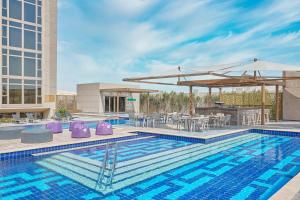 a swimming pool with a bar and a building at Hyatt Regency Cairo West in 6th Of October