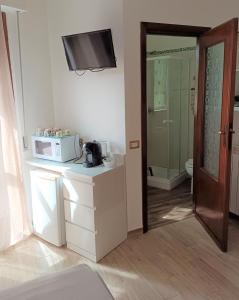 a small kitchen with a microwave and a bathroom at White Beach in Alghero