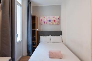 a small bedroom with a bed and a window at Hotel l'Hotera in Cannes