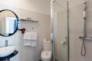 a bathroom with a shower and a toilet and a sink at Hotel l'Hotera in Cannes