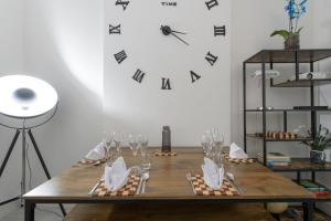 ロンドンにあるTower Bridge(TB1) Exclusive Two bedroom apartmentのワイングラス付きテーブル、壁掛け時計