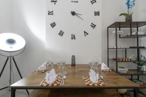 a table with wine glasses and a clock on the wall at Tower Bridge(TB1) Exclusive Two bedroom apartment in London