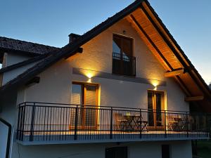 a house with a balcony with lights on it at Apartma ELA in Zgornje Gorje