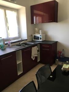 a kitchen with a sink and a microwave at Gîte les coquelicots in Morbier