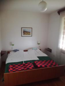 a bedroom with a bed with a checkered blanket at Rooms / Sobe Šolar - Brezje in Brezje
