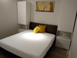 コラートにあるPaoli 28 Holiday Homesの小さなベッドルーム(白いベッド、黄色い枕付)